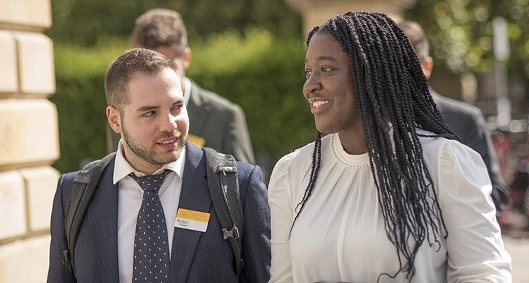 Students smiling while entering the Business School.