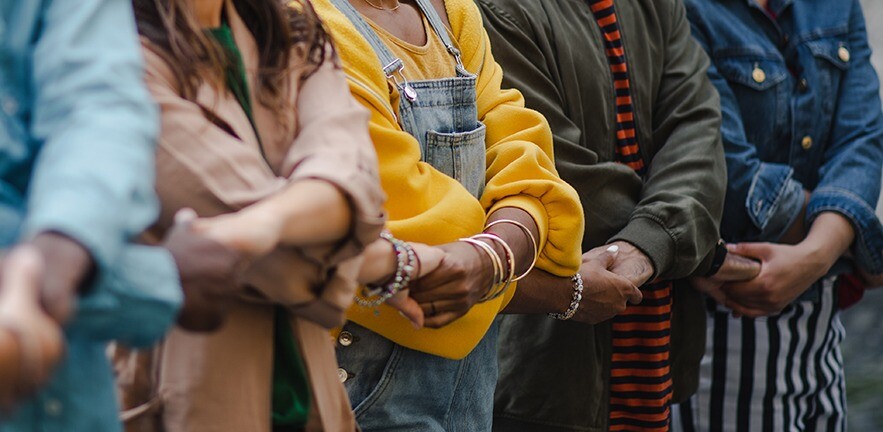 Community holding hands standing strong together to tackle inequality.