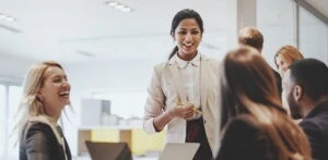 A group of people in the office smiling as they talk.