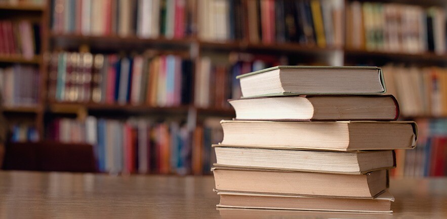 Close up of books on desk in library.