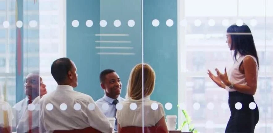 A female executive presents to a group of board members.