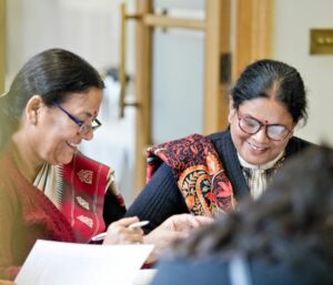 Female delegates laughing during a session.