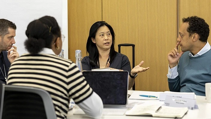 A woman and a man engaging in conversation in a classroom.