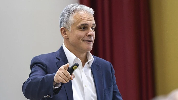 Stelios Kavadias smiling and teaching in a classroom.