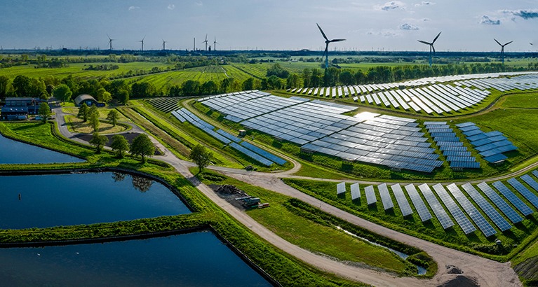 Landscape with green energy features: solar, wind and water power.