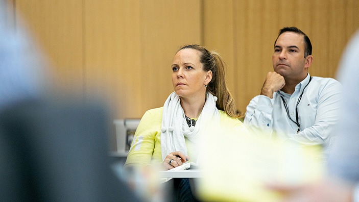 Woman and man listening intently in a classroom.