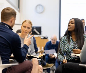 Two women engaged in conversation, listening intently.