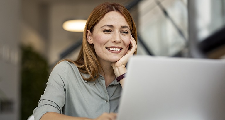 Smiling woman in front of a laptop.